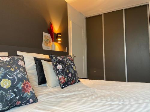 een slaapkamer met een bed met kussens erop bij Confort Home - Disneyland Paris à 10 minutes à pied- Marne la Vallée- Paris in Serris