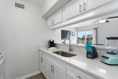 a kitchen with white cabinets and a sink at 261 G Madeira Beach Yacht Club in St Pete Beach