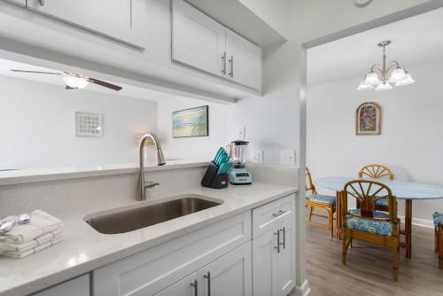 a kitchen with a sink and a dining room at 261 G Madeira Beach Yacht Club in St Pete Beach
