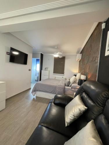 a bedroom with a bed and a couch and a bed at Vivienda en El Campello playa in El Campello