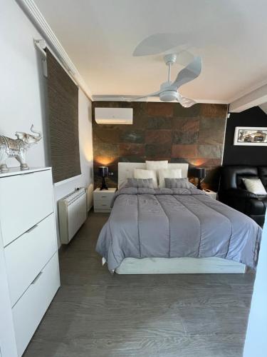 a bedroom with a bed and a stone wall at Vivienda en El Campello playa in El Campello