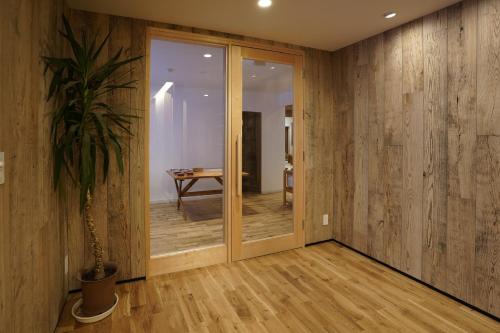 a hallway with wooden walls and a potted plant at Country Inn Milky House in Niseko