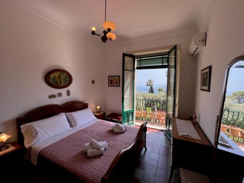 um quarto com uma cama e uma janela com vista em Papiro House em Taormina
