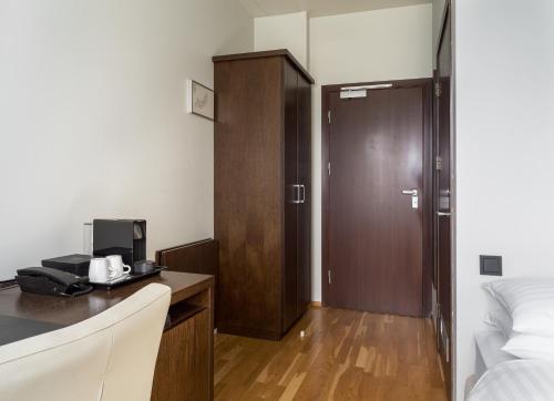 a hotel room with a bed and a desk with a microwave at Hotel Kea by Keahotels in Akureyri