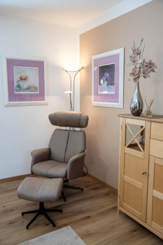a room with a chair and a table and a lamp at Geisbergerhof in Bad Birnbach