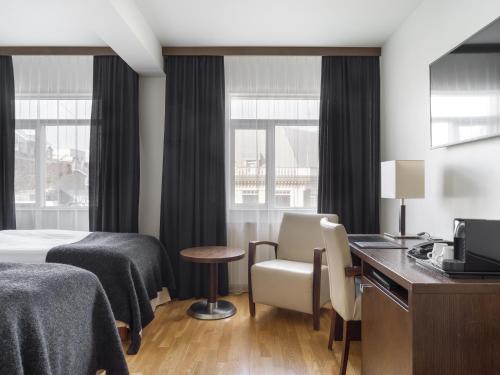 a hotel room with a bed and a desk and chairs at Hotel Kea by Keahotels in Akureyri