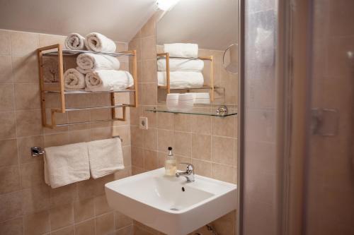 a bathroom with a sink and a shower with towels at Geisbergerhof in Bad Birnbach