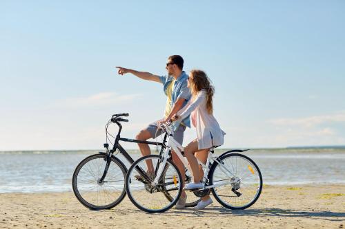 a man and a woman riding a bike on the beach at Aquamaris Strandresidenz Rügen in Juliusruh