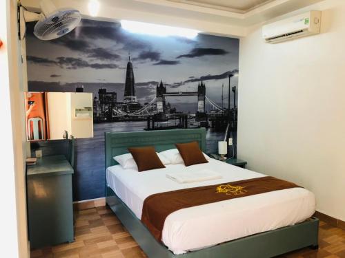 a bedroom with a bed with a painting on the wall at Cozi Hotel in Hai Phong