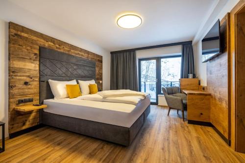 a hotel room with a large bed and a desk at Aparthotel Fuxbau in Flachau