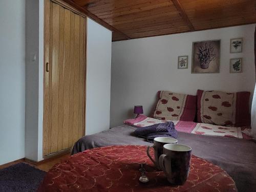 a bedroom with a bed and a table with two cups at Home Stay Słotwińska in Krynica Zdrój