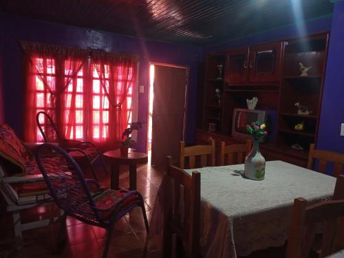 een kamer met een tafel met een vaas met bloemen erop bij Flia brover (Lalo) in Puerto Iguazú
