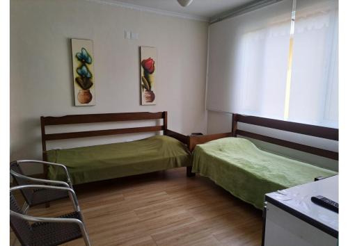a bedroom with two beds and a desk and a window at Descanso em Ambiente Familiar in Guarujá