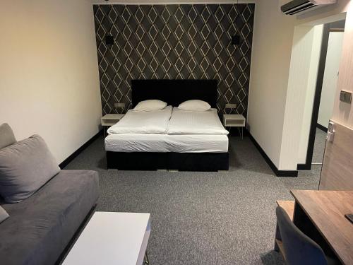 a small bedroom with a bed and a couch at Zajazd Gołębiowski in Lipsko