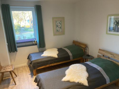 two beds in a room with a window at Ferienwohnung Am Holzfeld in Schneverdingen