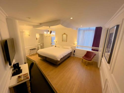 a bedroom with a bed and a desk and a window at Le Magic Hall in Rennes