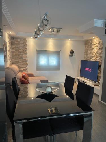 a living room with a couch and a tv at Vivienda en El Campello playa in El Campello