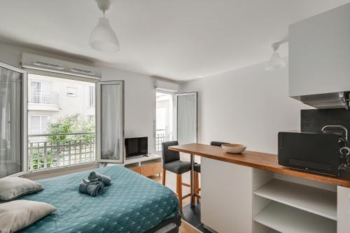 Cette chambre comprend un lit et un bureau avec un comptoir. dans l'établissement La Vallée-Chatenay Malabry, à Châtenay-Malabry