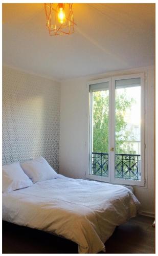 a bedroom with a bed and a large window at Cosy apartment PARIS XIIème in Paris