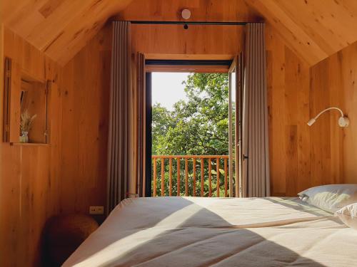 a bedroom with a bed and a large window at Lodge op de Berg in Bree