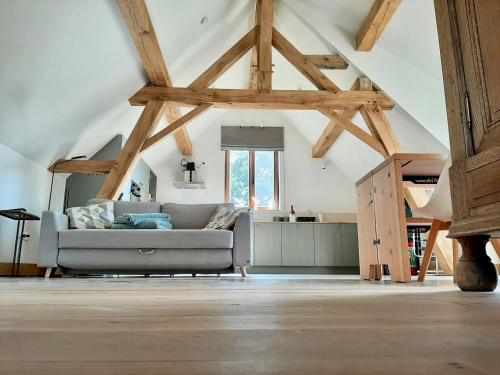 a living room with a couch in the attic at Lodge op de Berg in Bree