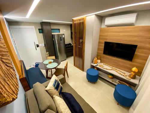 a living room with a couch and a tv at Flat Premium No Centro in Porto De Galinhas