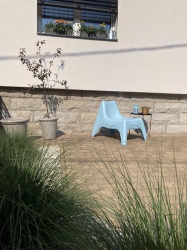 a blue chair sitting in front of a building at Apartmán ANA in Terchová
