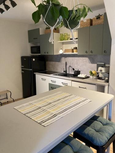 a kitchen with a white table with two stools at Apartmán ANA in Terchová