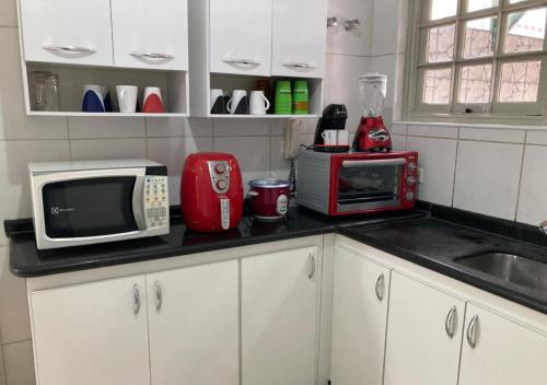 a kitchen counter with a microwave and a sink at WR7 Hostel in São Bernardo do Campo