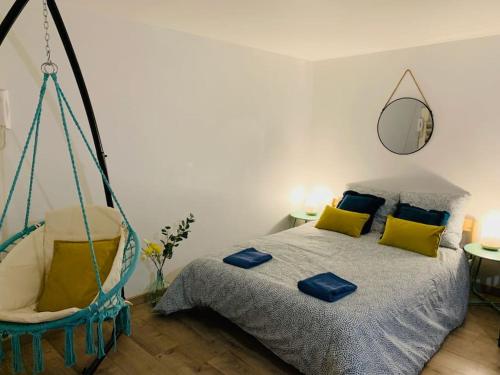 um quarto com uma cama e um baloiço de cama suspenso em cocooning modern design studio em Avesnes-sur-Helpe