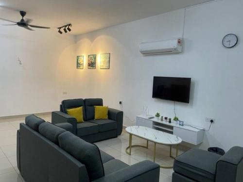 a living room with two couches and a tv at KY Happiness Homestay Tanjong Karang 快乐民宿 in Tanjung Karang