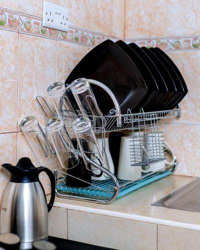 a drying rack with dishes and glasses on a kitchen counter at The Mbuya Residence in Kampala