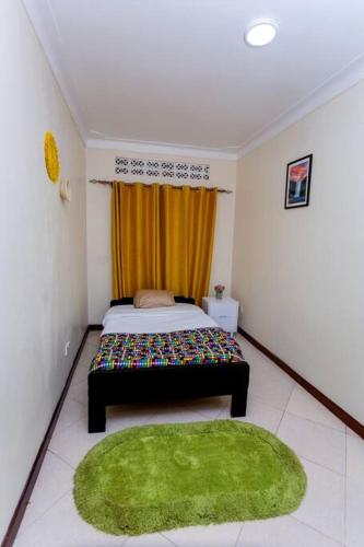 a bedroom with a bed and a green rug at The Mbuya Residence in Kampala