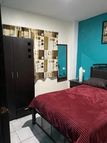 a bedroom with a bed and a red blanket at Bonito Departamento Verde con terraza in Cholula