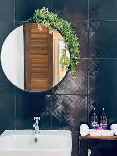 a bathroom with a mirror and a sink at SAK-KA-YA (สัก-กา-ยะ) in Mae Sot