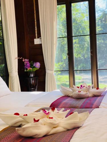 a bed with two baskets on it with flowers on it at SAK-KA-YA (สัก-กา-ยะ) in Mae Sot