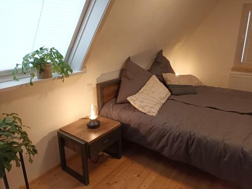 1 dormitorio con 1 cama y 1 mesa con lámpara en Lachberg9, en Dahn