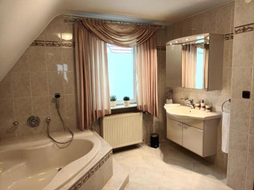 een badkamer met een bad en een wastafel bij Lachberg9 in Dahn