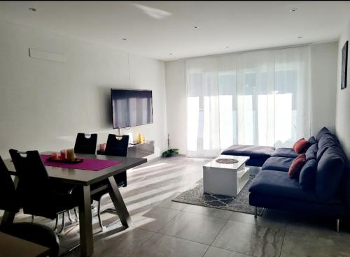 un soggiorno con divano blu e tavolo di GaLa Appartamento a Bellinzona