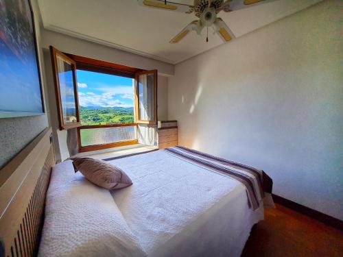 um quarto com uma cama grande e uma janela em Apartamento San Marcos by SanSe Holidays em San Sebastián