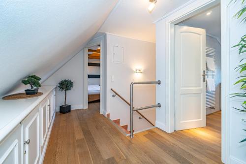 a hallway with a staircase leading up to a bedroom at Üüs Lek in Keitum