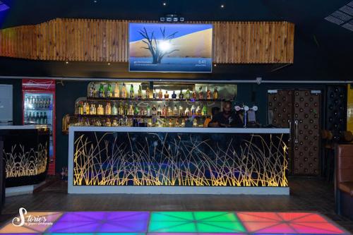 eine Bar mit einem TV über einer Bar mit Getränken in der Unterkunft NT Hotels and Resorts Akridha in Puducherry