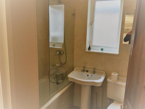 a bathroom with a sink and a shower and a toilet at Central Windsor House in Windsor