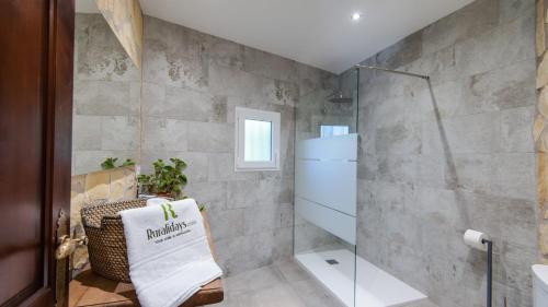 a bathroom with a glass shower stall and a chair at Villa Río Béjar Quesada by Ruralidays in Quesada