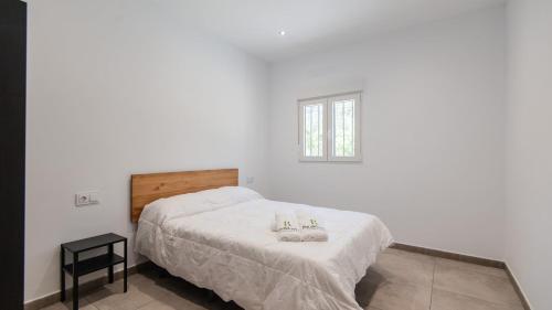 a white bedroom with a bed and a window at Villa Río Béjar Quesada by Ruralidays in Quesada