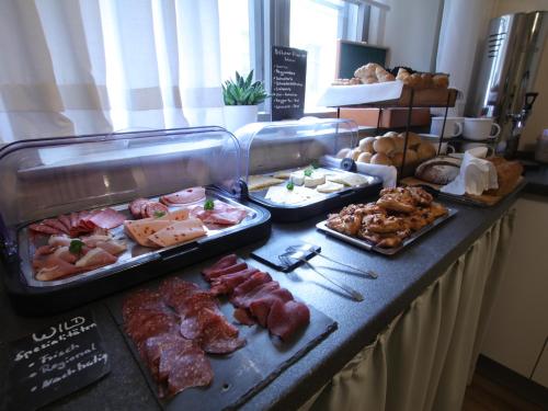 a buffet with different types of meats and pastries at Hotel Cranach-Herberge City Centre in Lutherstadt Wittenberg