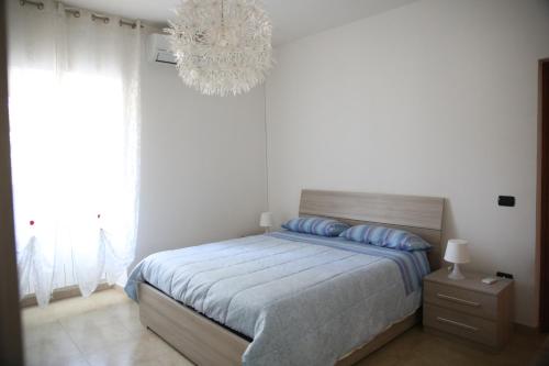 um quarto com uma cama e um lustre em Appartamenti da Anna em Montaquila