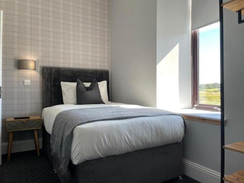 um quarto com uma cama grande e uma janela em The Lugton Rooms 