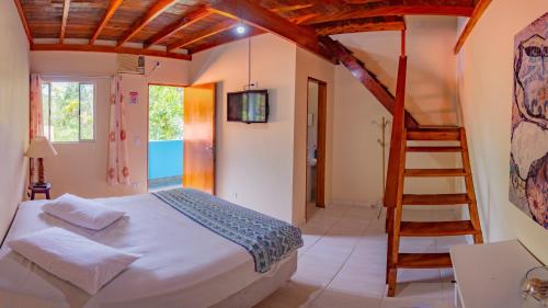 a bedroom with a bed and a ladder at Suítes da Barra in Ubatuba