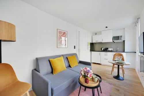 Stunning apartment 4P1BR في باريس: غرفة معيشة مع أريكة وطاولة